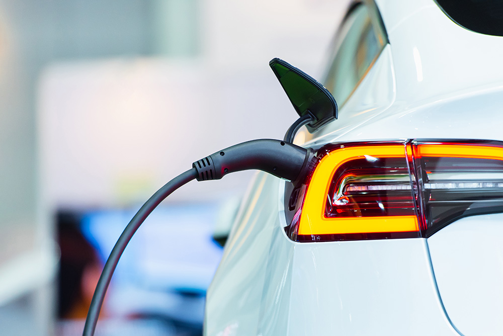 White electric vehicle (EV) plugged into a charger.